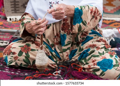 Antique spinning wheel in the hands of an old woman - Powered by Shutterstock