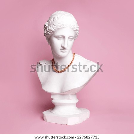 Antique statue bust of pretty woman in red beautiful necklace against pink background. Femininity. Concept of creativity, modernity and vintage, antique art. Inspiration and imagination