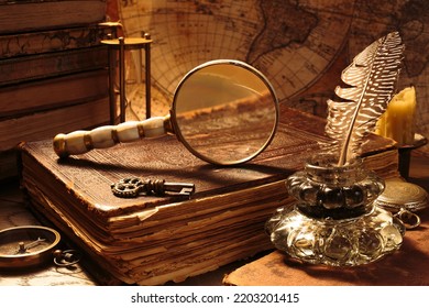 Antique still life. Medieval table of a traveler or navigator with magnifying glass, old bible, compass, quill pen, inkwell, sandwatch. - Powered by Shutterstock