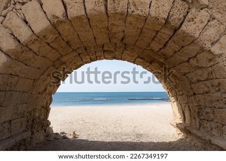 Antique stone arch in form of a tunnel with access to the sea beach coastline