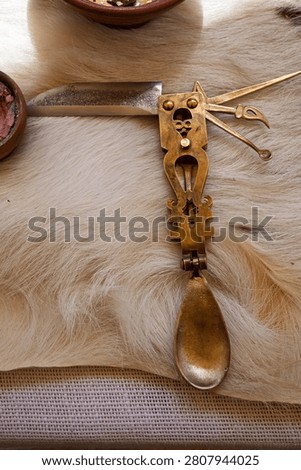 Antique style folding brass multitool featuring a spoon and knife, illustrating historical utility, ingenuity, and multipurpose survival.