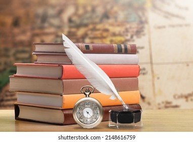 Antique table with books and inkwell with pocket watch. Vintage background. Concept history.