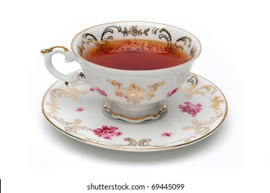 Antique tea cup full of tea on white background