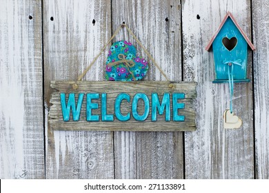 Antique Teal Blue Welcome Sign With Heart By Birdhouse Hanging On White Painted Weathered Wood Fence