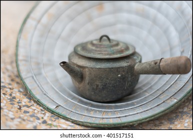 Antique Teapot Rests On A Marble Chair