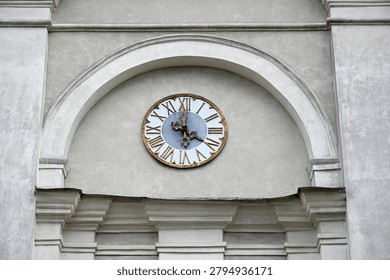 Antique tower clock mounted inside a stone architectural arch