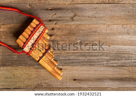 Antique traditional wind musical instrument Pan flute on old wooden background 