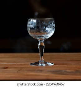 Antique Transparent Glass Wine Glass On A Black Background. Crystal Glass With Engraving. Glass Close-up