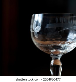 Antique Transparent Glass Wine Glass On A Black Background. Crystal Glass With Engraving. Glass Close-up