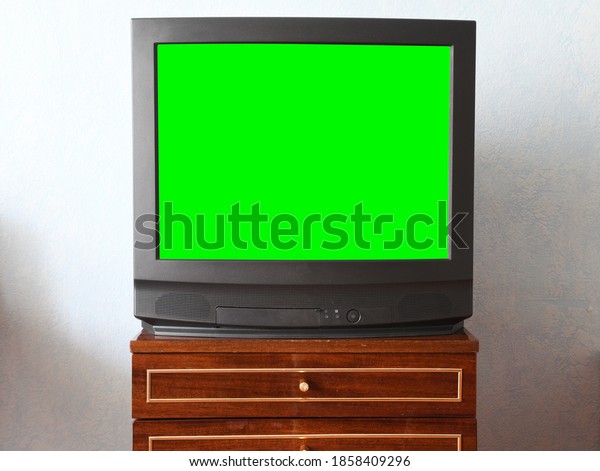 Antique TV with green screen on an antique
wooden cabinet, old design in a house in the style of the 1980s and
1990s.Interior in the style of the
USSR.