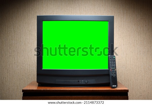 Antique TV\
with green screen on an antique wooden cabinet, old design in a\
house in the style of the 1980s and\
1990s.