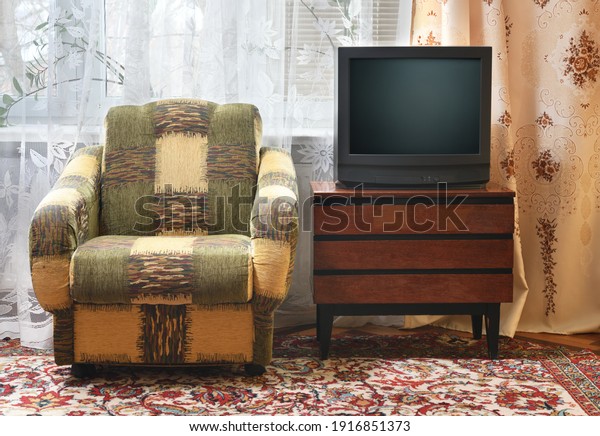 An antique TV stands on an old wooden cabinet,\
antique design in a 1980s and 1990s style home. Interior in the\
style of the USSR.