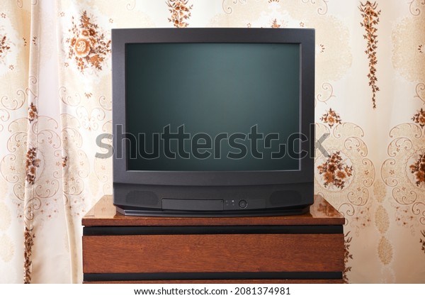 An antique TV stands on an old wooden cabinet,\
antique design in a 1980s and 1990s style home. Interior in the\
style of the USSR.