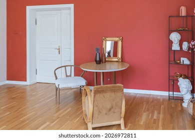 antique vintage interior in 19th century style living room with bright red walls, wood floor and direct sunlight inside the room.