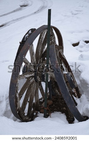 Antique wagon wheel in the snow