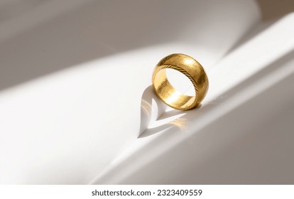 Antique Yellow Gold Ring with Heart Shaped Shadow on Blank book background in retro tone, Band Ring with heart shape reflection with copy space concept for Valentine's Day, Wedding,Engagement,Marriage - Powered by Shutterstock
