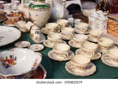Antiques on flea market or festival - vintage porcelain tea cups, tableware and other vintage things. Collectibles memorabilia and garage sale concept. Selective focus