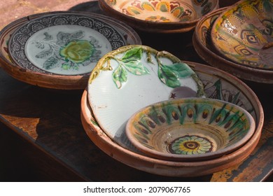 Antiques on flea market or traditional festival - vintage handmade ceramic dishes and plates from Kosiv region, Ukraine. Collectibles memorabilia and garage sale concept. Selective focus