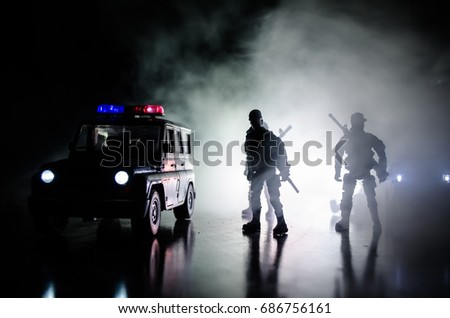 Anti-riot police give signal to be ready. Government power concept. Police in action. Smoke on a dark background with lights. Blue red flashing sirens. 