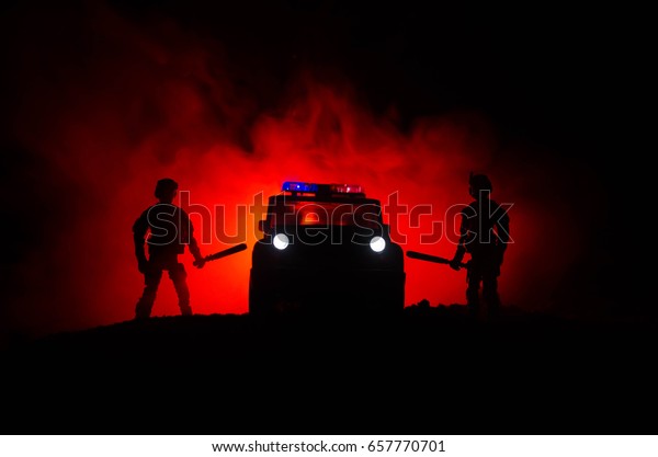 Anti-riot police give signal\
to be ready. Government power concept. Police in action. Smoke on a\
dark background with lights. Blue red flashing sirens. Dictatorship\
power