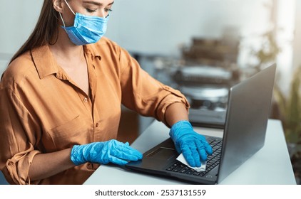 Antiseptic Treatment Concept. Girl in mask and gloves cleaning laptop keyboard with disinfectant - Powered by Shutterstock