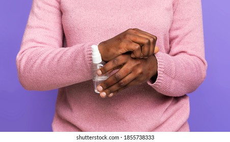 Antiseptic Use Consequences. Black Woman Scratching Irritated Skin With Eczema And Holding Bottle With Disinfectant, Suffering From Dermatitis And Itchy Skin, Standing On Purple Background, Cropped