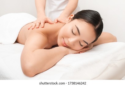 Anti-stress Thai massage. A beautiful Asian woman is getting a back massage at a Thai spa resort - Powered by Shutterstock