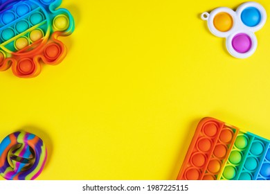 Anti-stress toys pop it, simple dimple, snapperz on yellow background, copy space. Concept trendy entertainment for fidget children, sensory toys, development of fine motor skills, stress relieving.