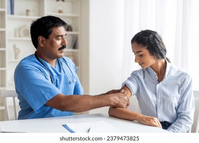 Antiviral Vaccination, Immunization. Middle aged medical worker sticking plaster bandage on patient's shoulder after injection in health centre, young eastern woman getting vaccine in modern clinic - Powered by Shutterstock