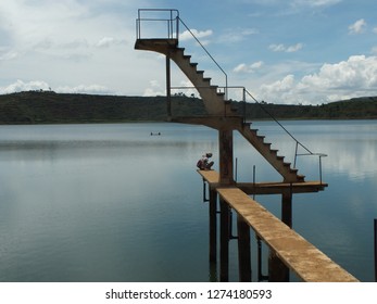 ANTSIRABE, MADAGASCAR – January 1, 2019: A Young Woman Alone Admires Lake Andraikiba At The Foot Of The Diving Board