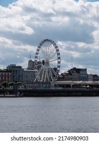 Antwerp, Belgium, 02 July 2022, The Ferris wheel on Antwerp right bank with the river Scheldt in the foreground, photo taken from left bank