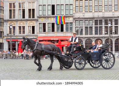 Antwerp, Belgium - August 11, 2015: Tourists making a ride in a horsecar at a medieval square downtown in the city Antwerp
