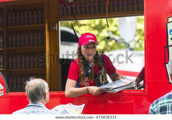 ANTWERP, BELGIUM - JULY 6,\
2015: A stewardess, inside a van Vittel mineral water company,\
delivers newspapers during concentration of the Tour de France\
riders in the city.