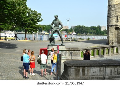 Antwerp city, Province Antwerp , Belgium - June 18, 2022: Lange Wapper standing with open legs is a giant of Antwerp folklore. Tourists in front of Lange Wapper statue and Het Steen fortress