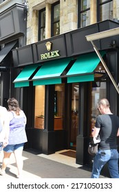 Antwerp city, Province Antwerp, Belgium - June 18, 2022: 3 caucasians seen from backside walking in front of Colman "Official Rolex Retailer" on a Saturday sunny morning