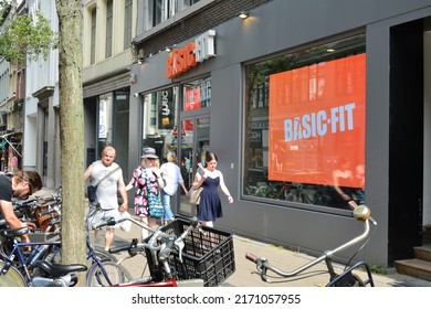 Antwerp city, Province Antwerp, Belgium - June 18, 2022: a middle aged caucasian couple and a seventeen year old girl passing in front of a chain fitness centre