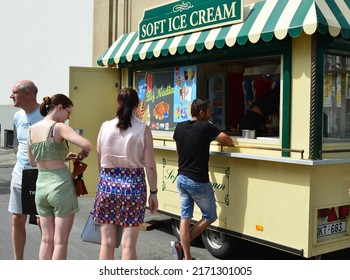 Antwerp City, Province Antwerp, Belgium - June 18, 2022: Passers-by  Caucasians In The Street Stop At An Ice Cream Vintage Truck To Order An Ice Cream With Such A Warm Late Spring Saturday Morning