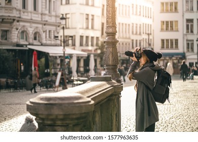 Antwerp, Kingdom of Belgium. Tourists Walking in the square. Female young traveler with backpack and professional photocamera in the old town.