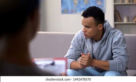 Anxious drug addicted black teenager suffering withdrawal, psychotherapy session