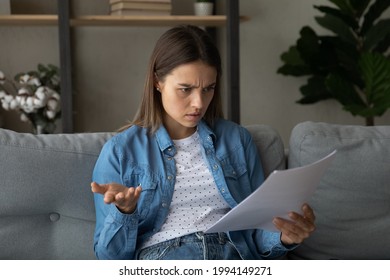 Anxious frustrated unhappy young woman looking through paper letter, feeling stressed of reading unpleasant information or bad news, financial bank notification with mistake or loan rejection notice.