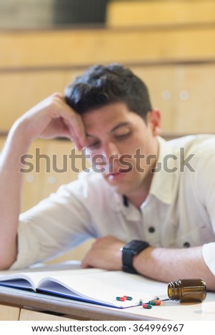 Anxious male student during exam in lecture hall