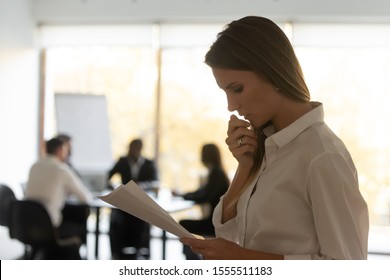 Anxious Millennial Caucasian Woman Stand Outside Boardroom Read Look Through Papers Get Ready For Speech, Scared Frustrated Female Speaker Repeat Consider Document Worried Before Public Speaking