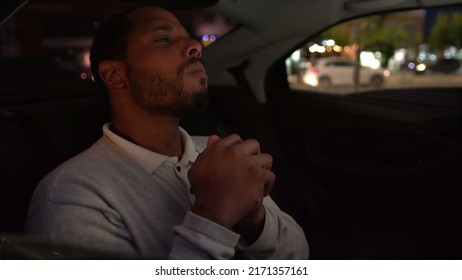 Anxious Person In Car Backseat Commuting At Night After Work Inside Taxi Cab. Worried Emotion Of One Black Man Inside Car