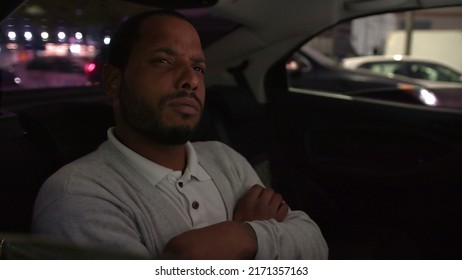 Anxious Person In Car Backseat Commuting At Night After Work Inside Taxi Cab. Worried Emotion Of One Black Man Inside Car