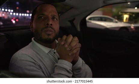 Anxious Person In Car Backseat Commuting At Night After Work Inside Taxi Cab. Worried Emotion Of One Black Man Inside Car