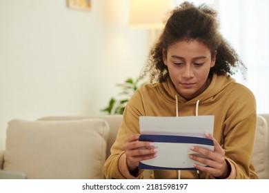 Anxious Teenage Girl Opening Acceptance Letter From University