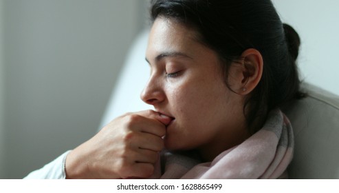 
Anxious woman biting nails with hand. Girl feeling anxiety nervousness, stressed out on sofa