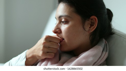 
Anxious woman biting nails with hand. Girl feeling anxiety nervousness, stressed out on sofa