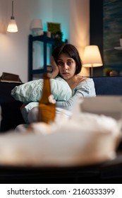 Anxious Woman In Pain Feeling Depressed And Pensive, Siting On Sofa. Frustrated Adult With Depression, Anxiety And Chronic Disease Difficulties Feeling Sad In Messy Dirty Living Room.