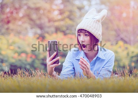 anxious young girl looking at phone seeing bad news or photos there with disgusting emotion on her face,surprise
